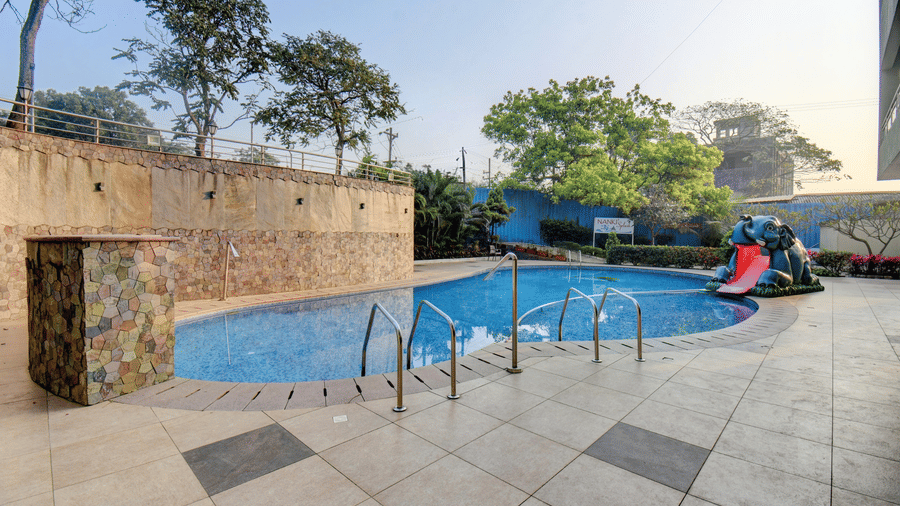 Poolside deck with lounge space and blue water views at VITS Lonavala.