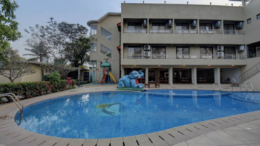 Hotel exterior view with large swimming pool at VITS Lonavala.