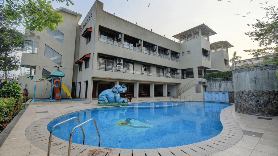 Resort building overlooking the pool and landscaped surroundings at VITS Lonavala.