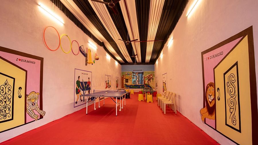  A fun indoor space featuring a ping pong table, bright red flooring, and animated decor on the walls, designed for leisure activities - VITS Select Diamond Resort, Sasan Gir