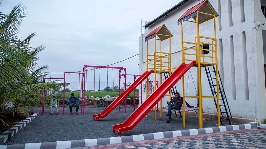 An outdoor play area featuring yellow and red slides and a jungle gym, set against a clear sky - VITS Select Diamond Resort, Sasan Gir