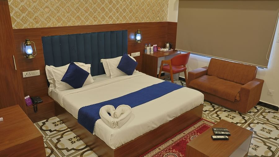A hotel room at VITS Select Diamond Resort, Sasan Gir, with a bed, desk, and a sofa