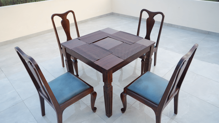  Outdoor terrace seating with a square wooden table and four chairs overlooking the surroundings.
