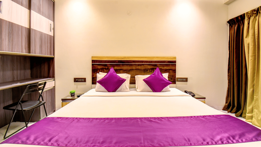Super Deluxe Room king bed with purple linen, work desk and wardrobe at VITS Select Kharadi Pune