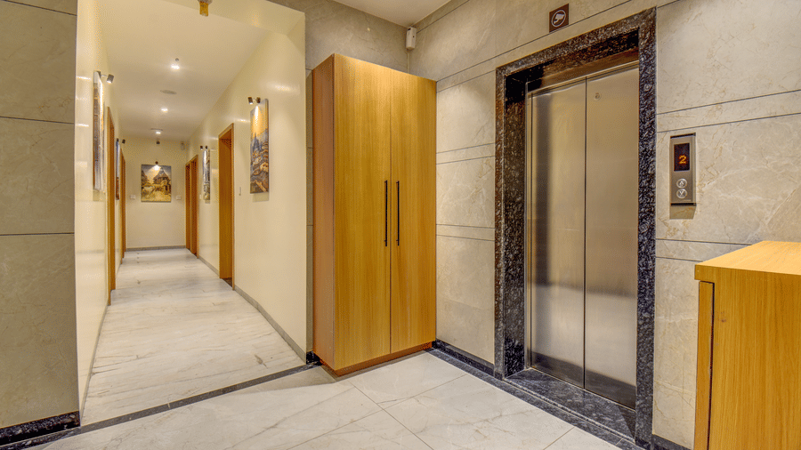 Hotel corridor with lift access, marble flooring, and wooden doors at VITS Select Nashik Hotels & Resorts