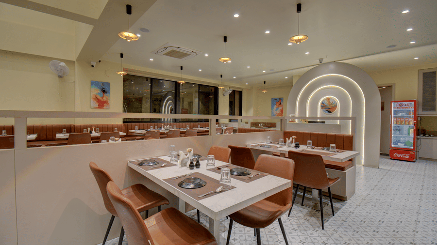 Restaurant space showing multiple tables, warm lighting, and decorative arches at VITS Select Nashik Hotels & Resorts.