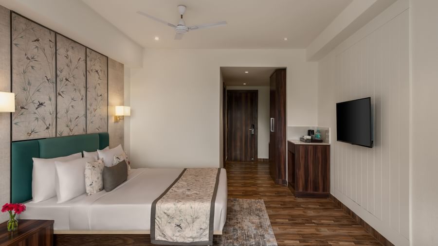 Room interior at Voyage Milestone Hotel and Banquet with twin beds and bedside lamps.
