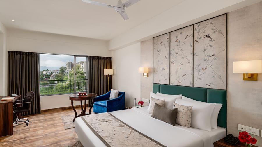 Comfortable room at Voyage Milestone Hotel and Banquet with seating area and balcony access.