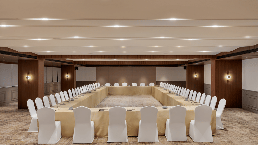 Seating arrangement on patterned carpet at Aura at Voyage Milestone Hotel And Banquet under warm lighting