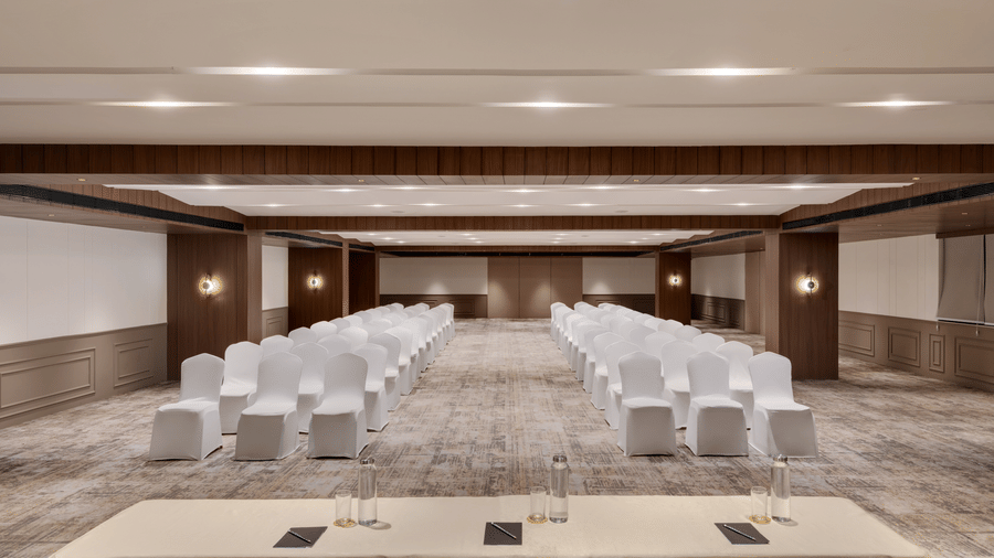 Aura hall at Voyage Milestone Hotel And Banquet featuring chairs arranged in classroom setting facing another set of 3 chairs with a table in front of them