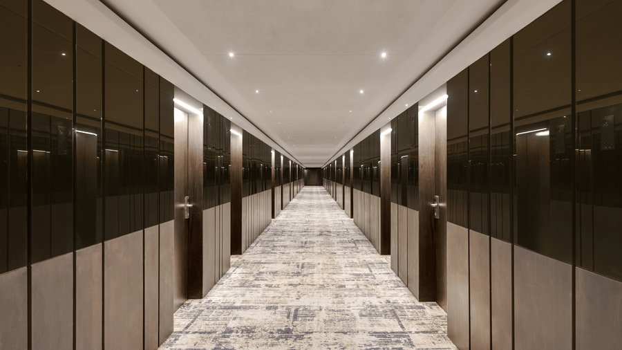 Corridor of Voyage Milestone Hotel And Banquet featuring running patterned carpet and doors to rooms facing each other