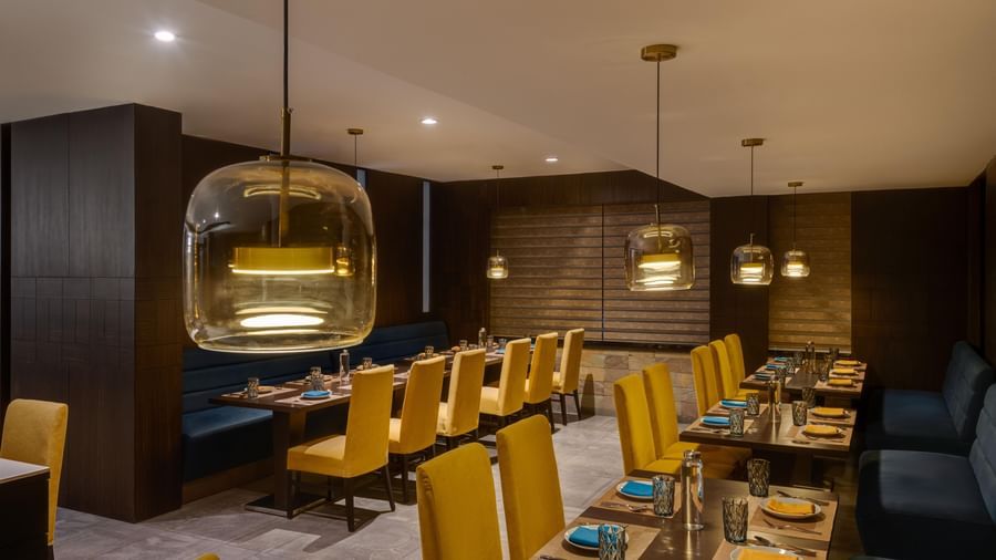 Lounge at Voyage Milestone Hotel and Banquet featuring blue sofas and a decorative wall design.