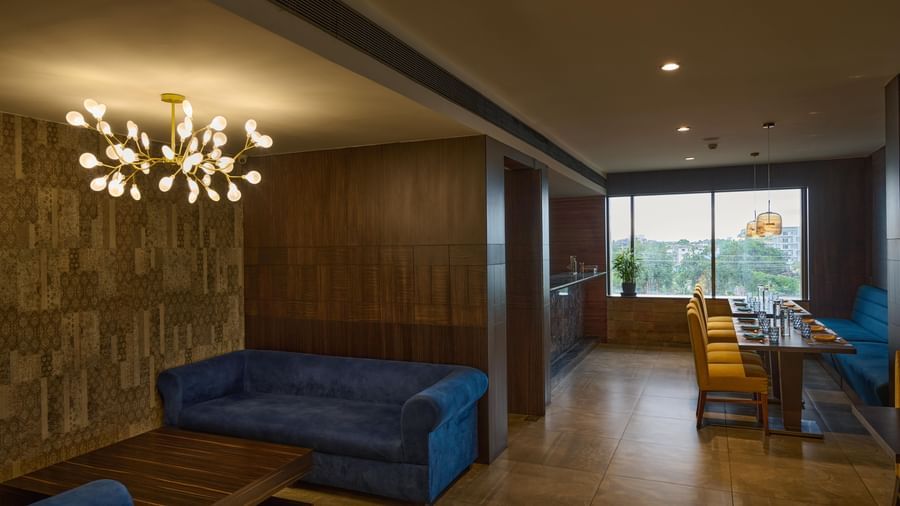 Dining space at Voyage Milestone Hotel and Banquet with yellow chairs and neatly arranged tables.