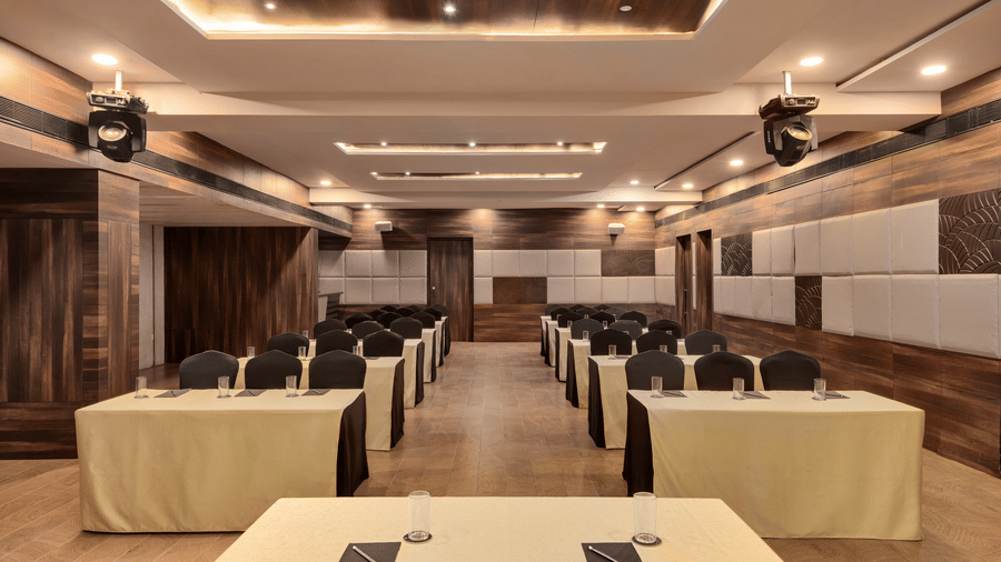 Spectrum hall at Voyage Milestone Hotel And Banquet featuring a table facing chairs and tables arranged in classroom setting in 2 rows