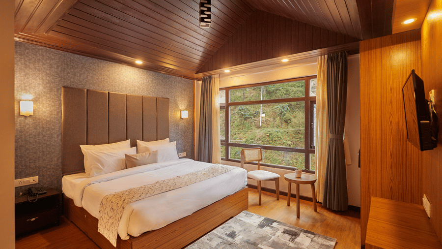 A bedroom suite with an vaulted wooden ceiling and views of the surrounding greenery | Voyage Rodhi Resort