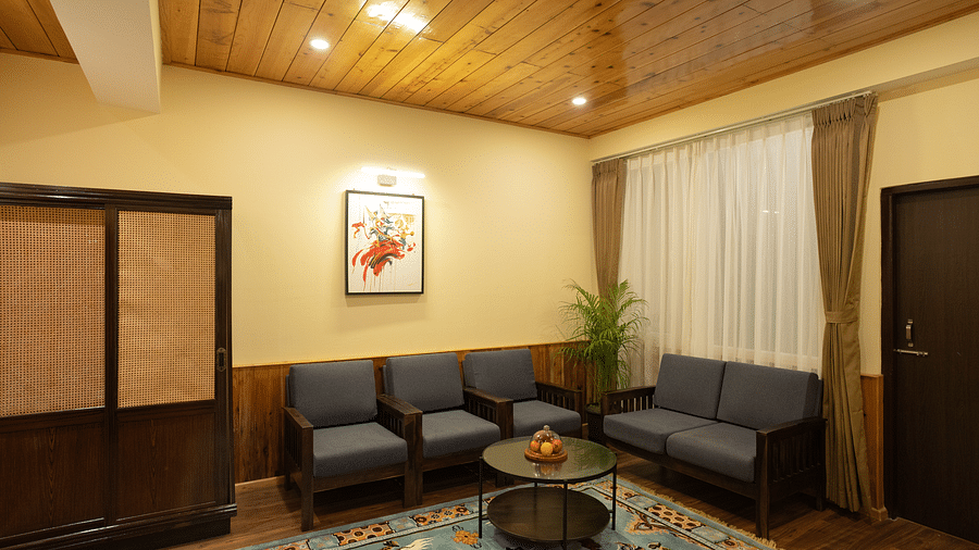 Sofa chairs arranged in the living area with a carpet and teapoy | Voyage The Royal Retreat, Gangtok