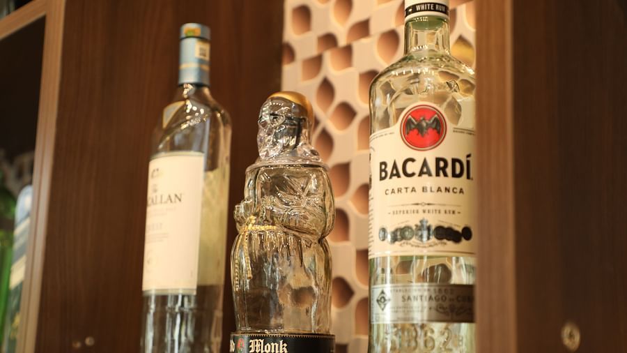 Alcohol bottles placed on brown wooden shelf