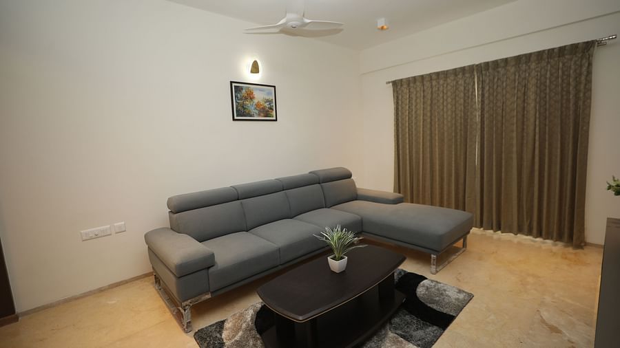 Grey couch with black table in front and matching carpet on the floor
