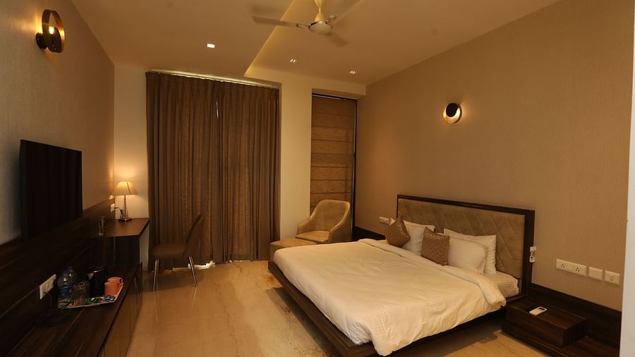 Hotel bedroom interiors with chairs television and a white king size bed