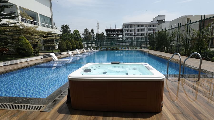 Open air jacuzzi placed beside an expansive pool