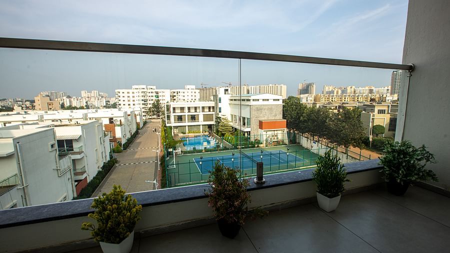 View from the balcony with small plant pots and an open-air swimming pool