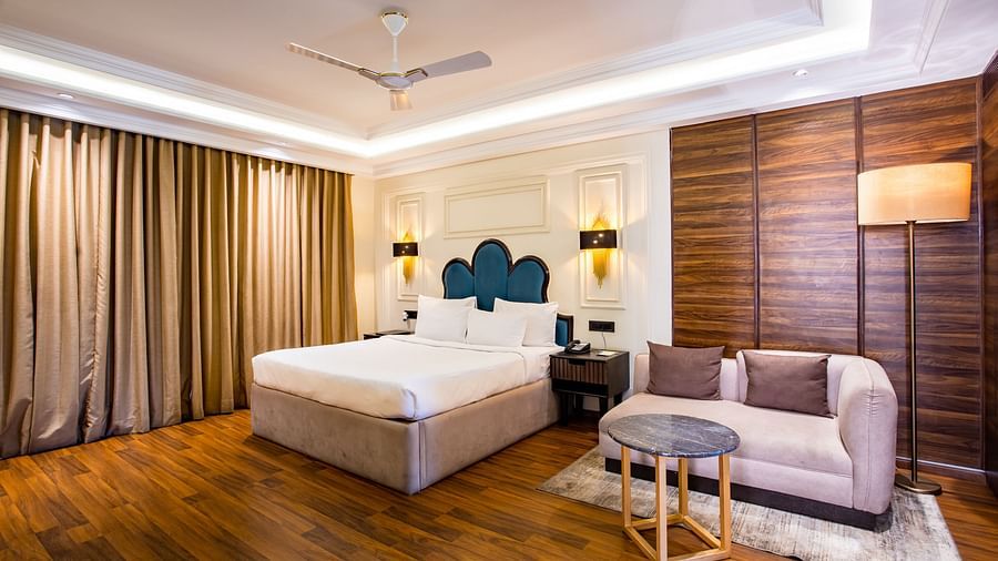 One of the rooms at Wedlock Greens Hotel & Resort Dhanbad features a double bed with a sofa, ideal for a comfortable stay in a couple room in Dhanbad