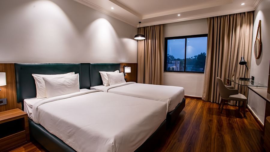 twin beds with led lights on inside one of the rooms - Wedlock Greens Hotel Resorts Dhanbad