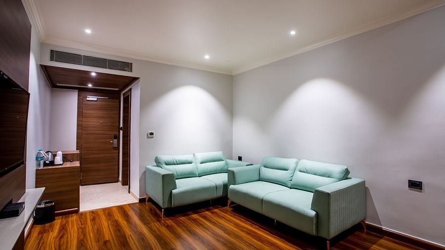 an overview of the living room with sofas inside one of the rooms - Wedlock Greens Hotel Resorts Dhanbad