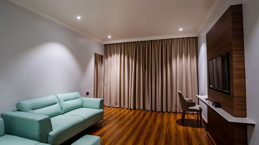 an overview of the living room with sofas inside one of the rooms - Wedlock Greens Hotel Resorts Dhanbad
