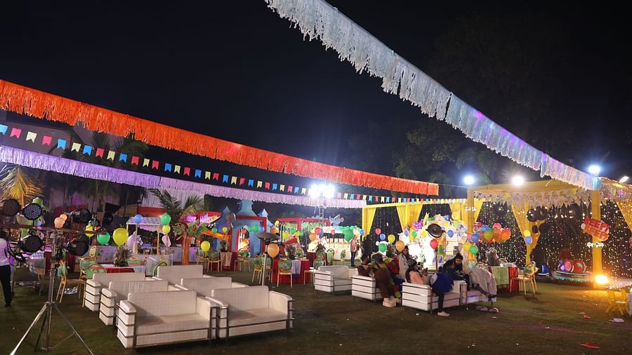 People gather in the outdoor venue, which is decorated for a celebration. - Wedlock Greens Hotel Resorts Dhanbad