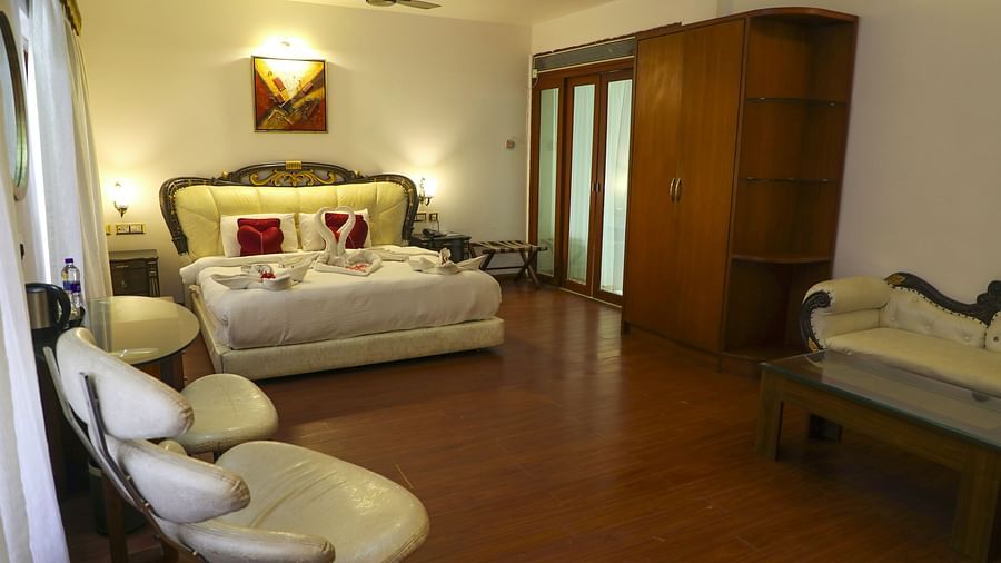 a double bed with seats on the side at King Suite - White pearl suites by rosetum 