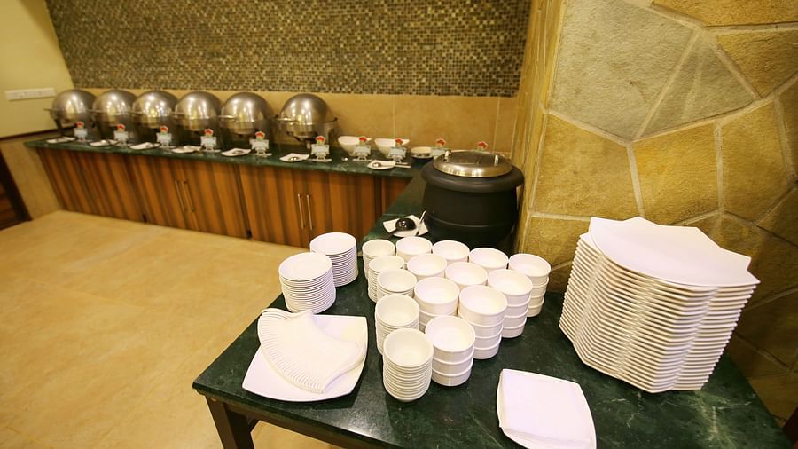 the buffet spread and a table full with trays and glasses at the conference hall in Lonavala - the indoor seating space at the banquet hall in Khandala - Zara's Resort