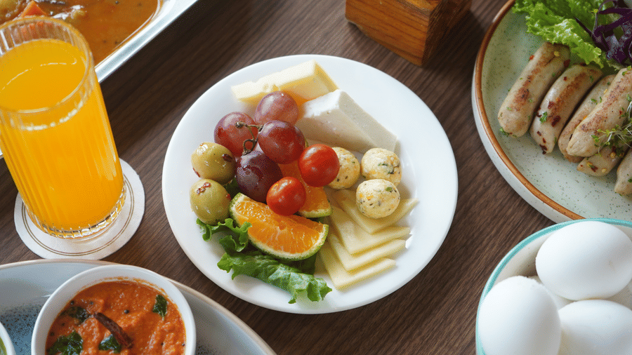 table set with a fruit salad, orange juice, bread, and boiled eggs at The Golden Tusk, Jim Corbett