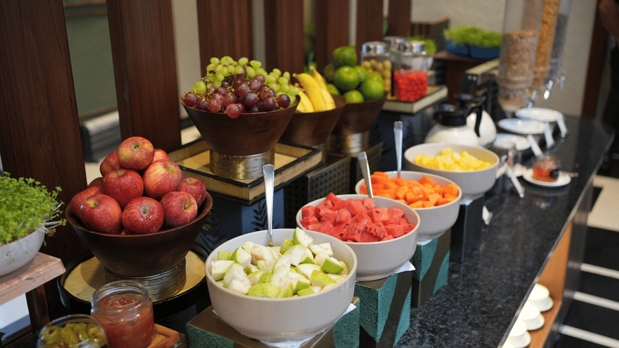 buffet table displaying various fresh fruits and salads in large bowls at The Golden Tusk, Jim Corbett