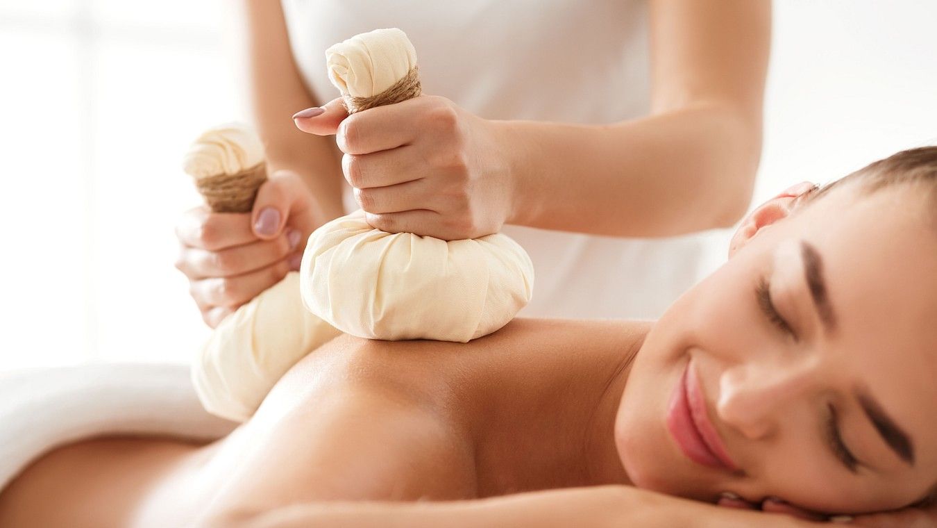 A woman recieving massage on her back while lying on her stomach