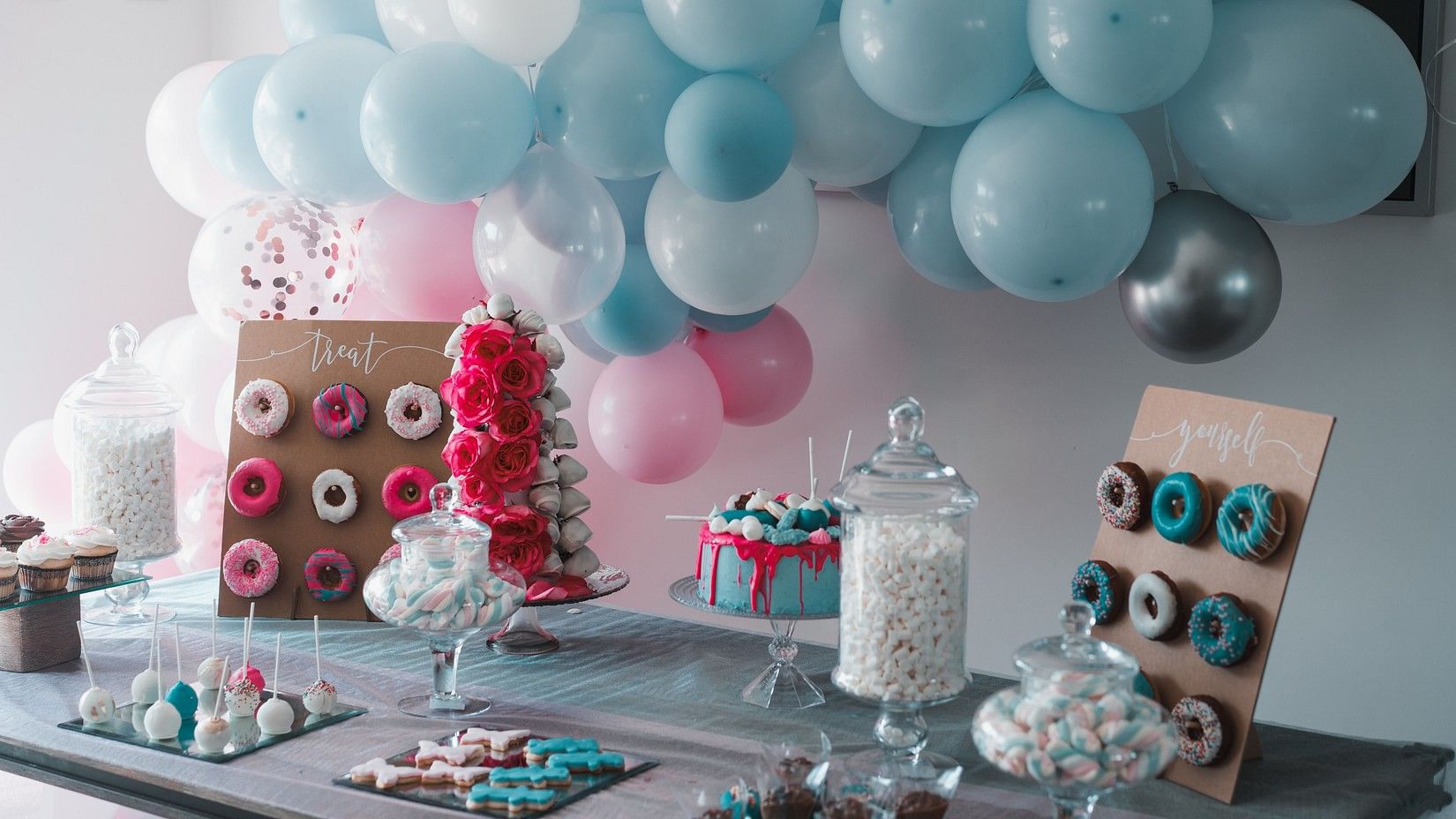 A table decorated with birthday arrangements and balloons in the background