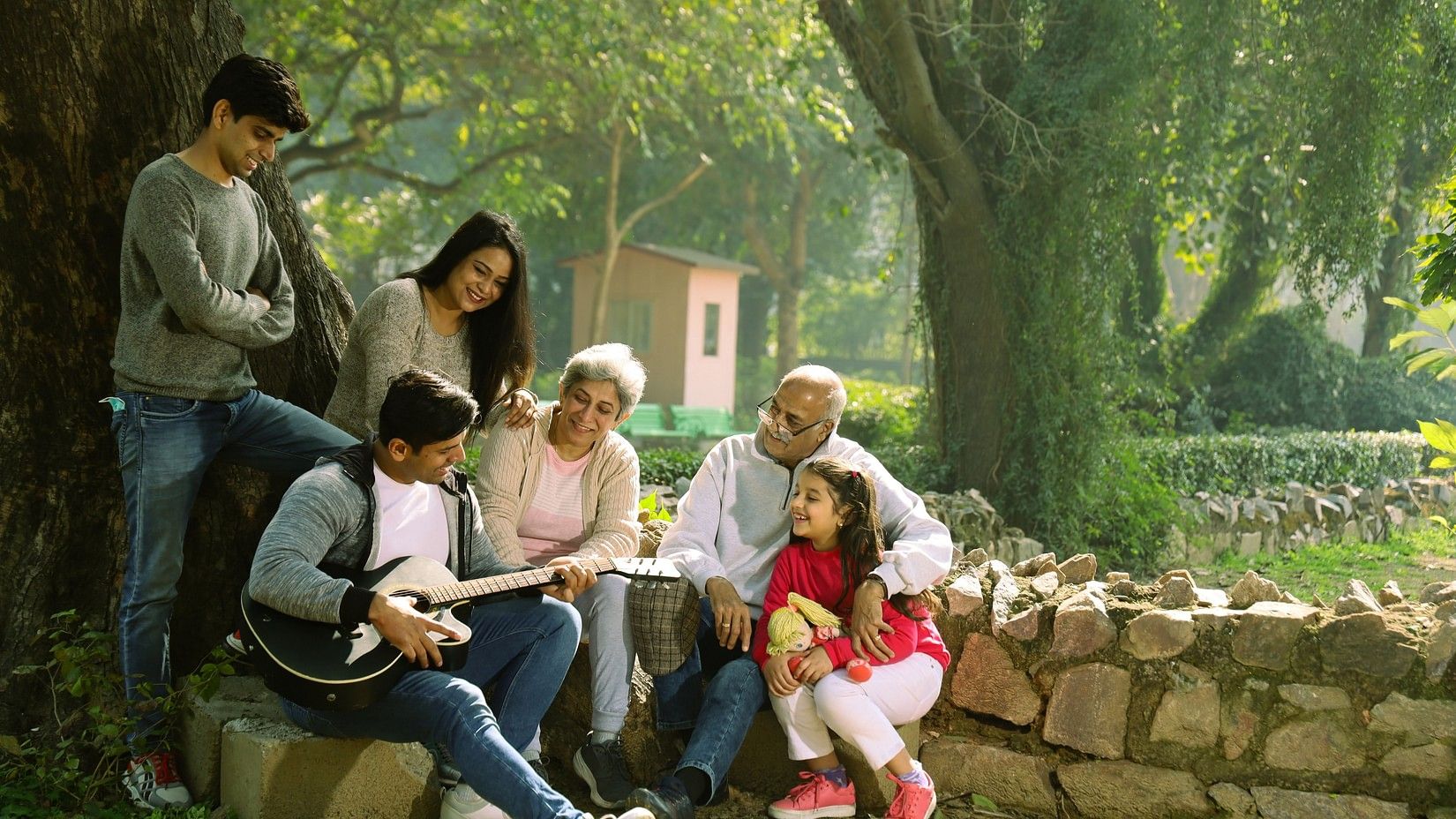 A family sitting in a area surrounded by trees and having fun