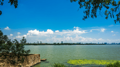 A tranquil waterway surrounded by lush vegetation, with boats gently gliding on the surface
