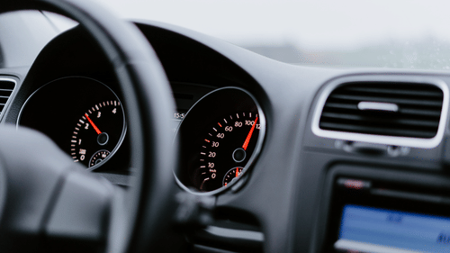 close up of a car front seat with stearing and the front board. 
