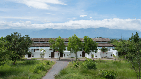 Facade of The Serai Bandipur with buildings surrounded by trees, the perfect place for a Bandipur Night Stay