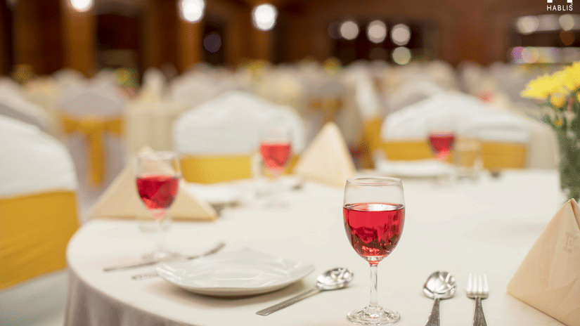 Plates, cutlery and welcome drink on the table at Hablis Hotel, Chennai.