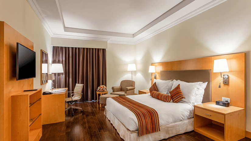A room featuring a double bed with side tables and lamps on them at Ramada by Wyndham Addis, Addis Ababa.