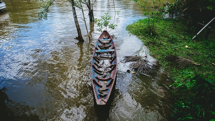 A close-up shot of a wooden boat with rustic wooden planks floating on the calm waters of a lake