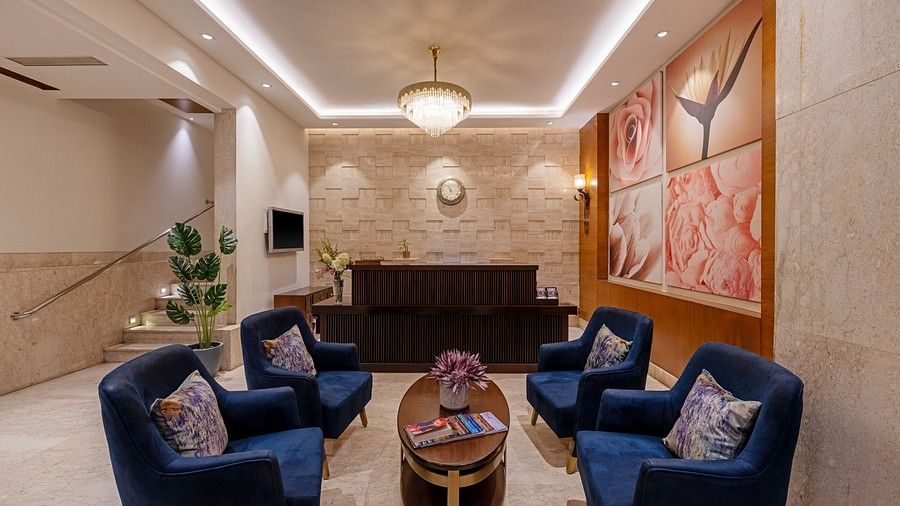 Lobby view with four blue  loveseats and a wooden center table