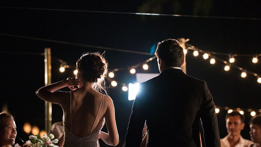 back shot of the couple after the wedding with a black night sky in the background facing the guests - Maikhao Dream Villa Resort & Spa, Phuket
