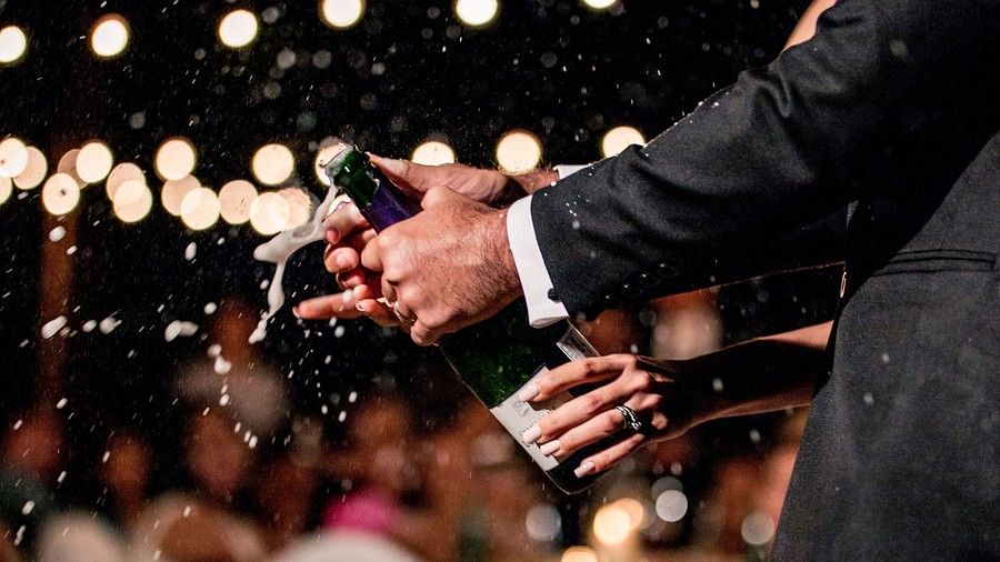 image of a man opening a bottle of champagne as the drink splutters out - Maikhao Dream Villa Resort & Spa, Phuket