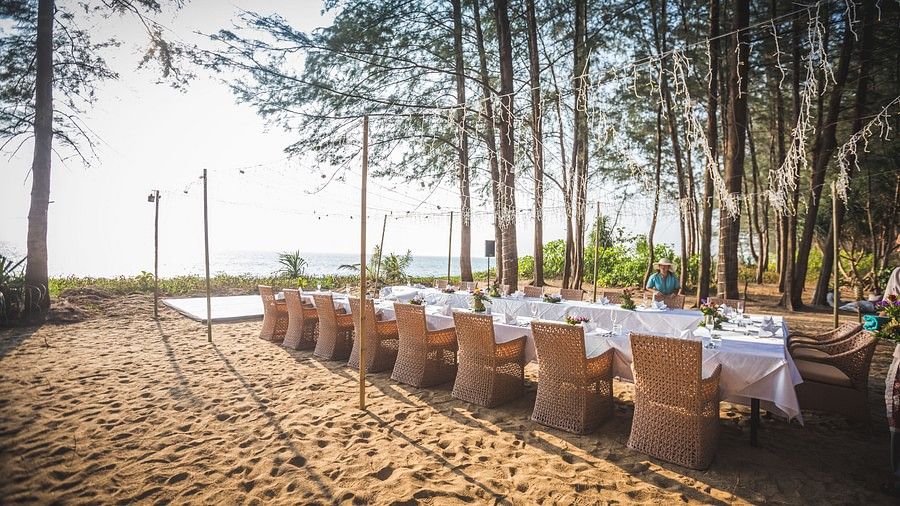 image of the entire dinig setup at the beach side overlooking the beautiful sea and the sky at maikhao dream villa resort & spa, phuket