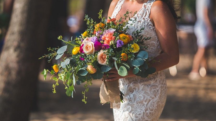 image of a woman dresses in a beautiful wedding gown walking down the aisle with a flower bouquet in her hands - Maikhao Dream Villa Resort & Spa, Phuket