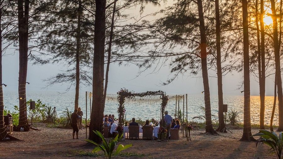image of the wedding dinner from a far away perspective with a beautiful sunset in the background - Maikhao Dream Villa Resort & Spa, Phuket