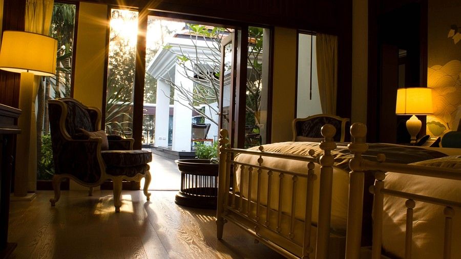 image of a bedroom with twin beds showcasing a bright sun outside the the room - two bedroom private pool beachfront villa